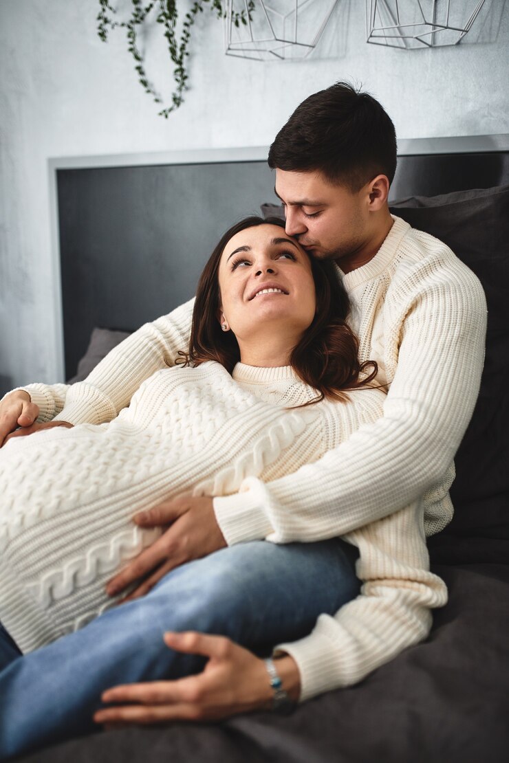 Photo loving pregnant couple, lie on the bed and look at each other. in anticipation of the baby, a new life, happiness and problems of a young family at the birth of a child.