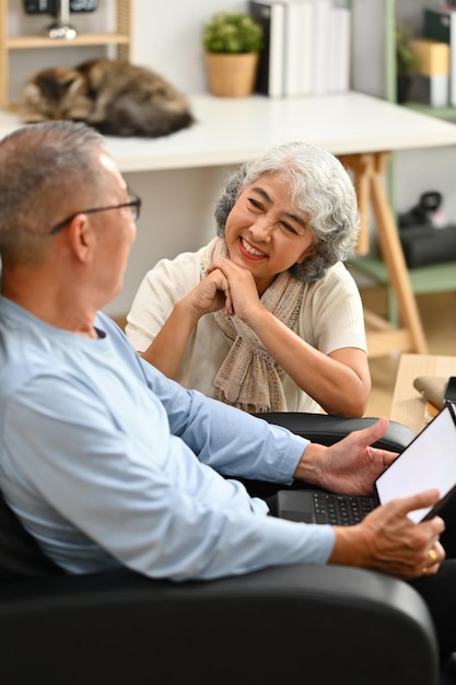 Loving senior couple having a conversation together while relaxing in cozy home Elderly lifestyle