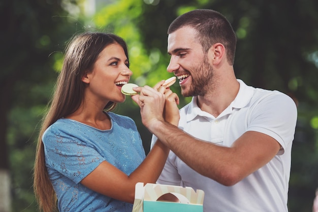 Loving young couple on a date at the park eating sweets