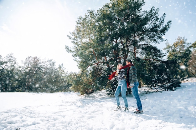 愛する若いカップルが雪に覆われた森の山で休んでいます。ジョイントレストのコンセプト