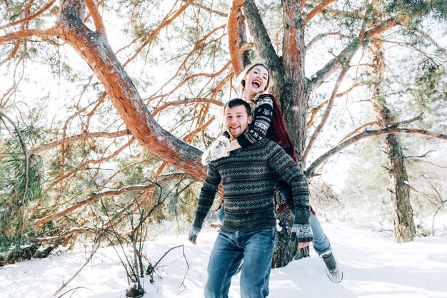 A loving young couple is resting in the mountains in a snow-covered forest. concept of joint rest