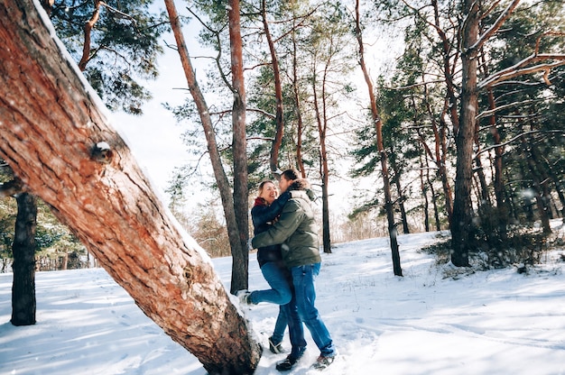 愛する若いカップルが雪に覆われた森の山で休んでいます。ジョイントレストのコンセプト