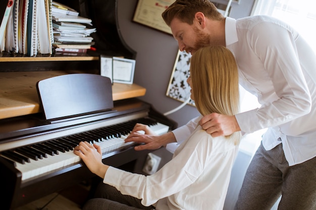 Loving young couple playing piano