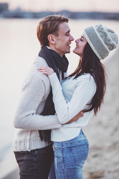 Photo loving young couple walk on the beach in autumn