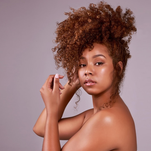 Amare i tuoi capelli naturali è uno studio afrodisiaco naturale di una bella giovane donna in posa su uno sfondo rosa