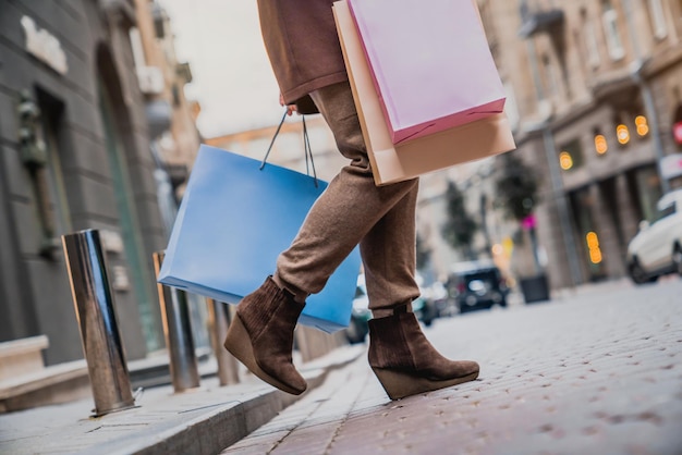 Low angle cropped shot of woman with shopping bags enjoying shopping at the city streets