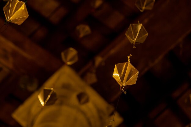 Low angle detail of a golden diamond hanging from the wooden
ceiling of the granollers porch