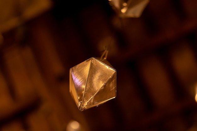 Low angle detail of a golden diamond hanging from the wooden\
ceiling of the granollers porch