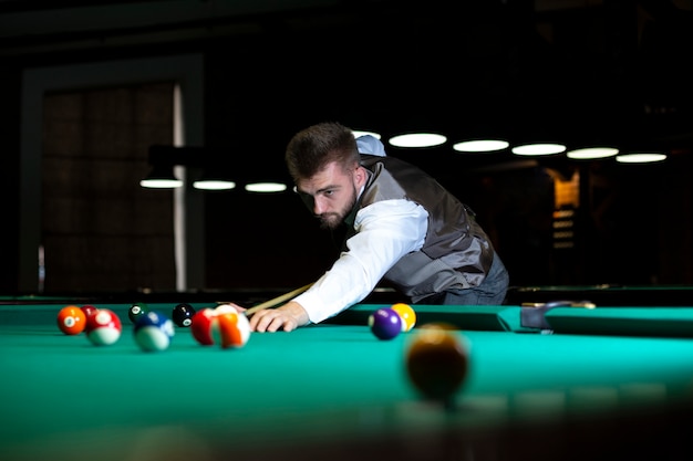 Photo low angle elegant guy playing billiard