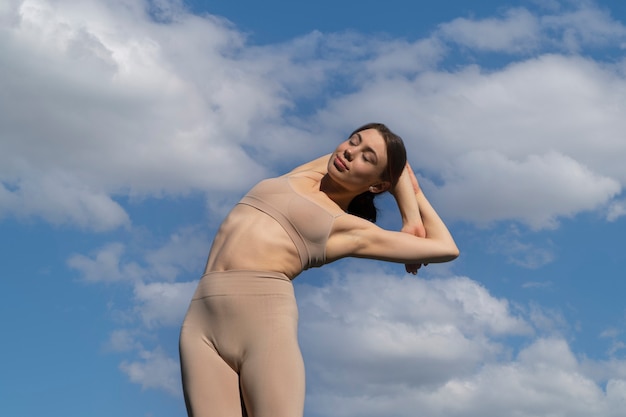 Foto donna in forma di angolo basso che fa yoga in natura