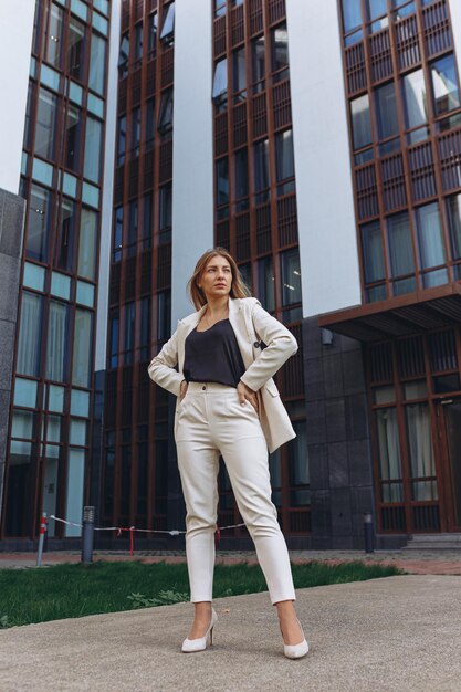 Low angle full body of confident well dressed female entrepreneur with blond hair