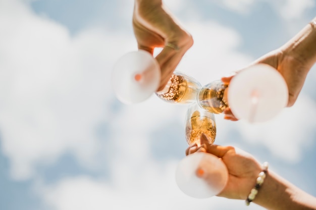 Low angle galsses with champagne and clouds view