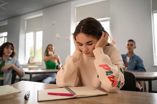 Foto ragazza di basso angolo vittima di bullismo a scuola