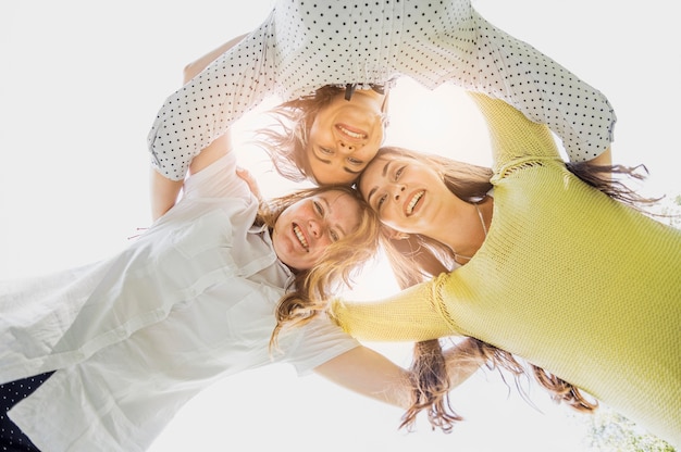 Low angle girls hugging and looking down