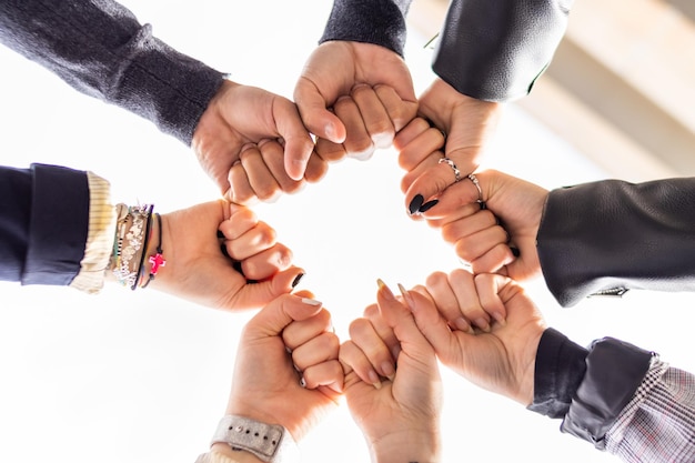 Low angle of group of people bumping fists Togetherness and togetherness concept