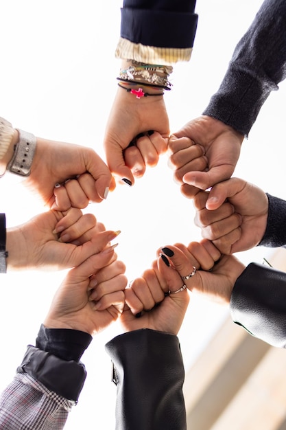 Low angle of group of people bumping fists Togetherness and togetherness concept
