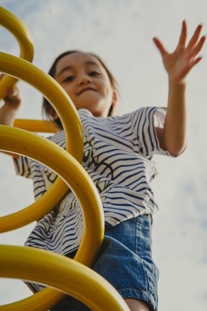 Photo low angle a little girl playing at the playground