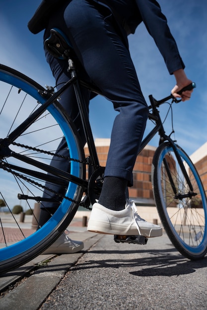 Photo low angle man going to work on bicycle