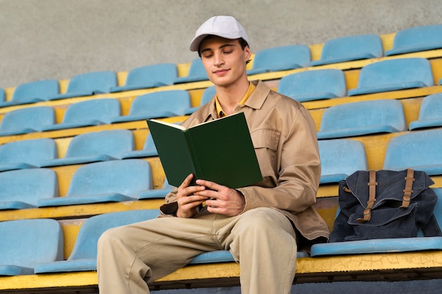 Low angle man reading in grandstands