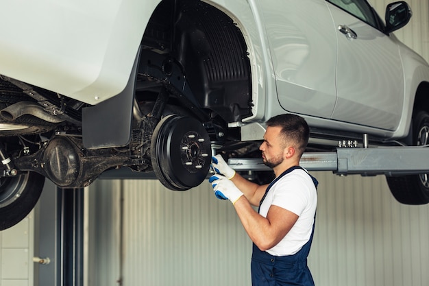 写真 車のホイールをチェックするローアングル機械式オス