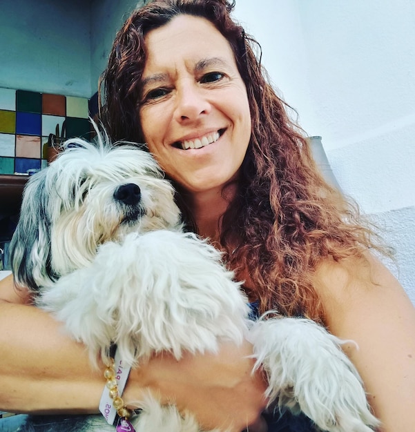 Photo low angle portrait of happy woman with dog at home