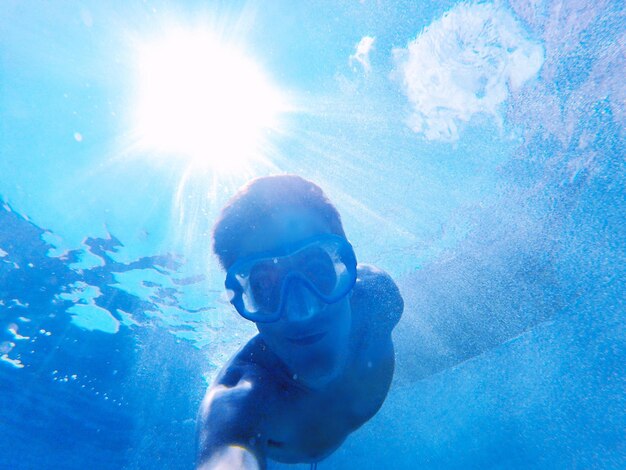 Low angle portrait of young man swimming in sea