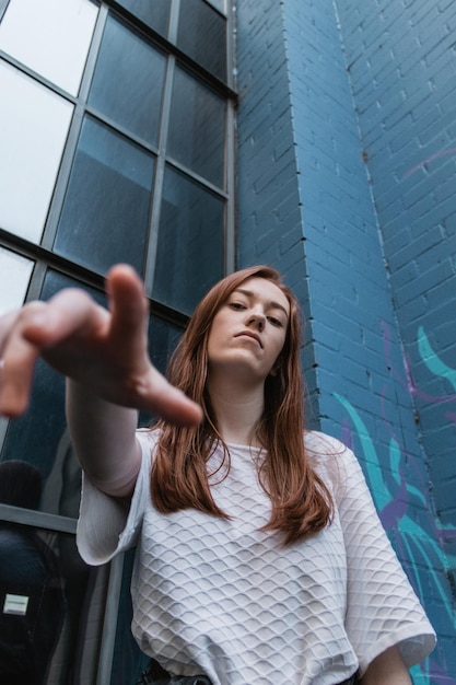 Photo low angle portrait of young woman standing against wall