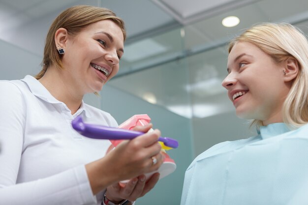 Low angle shot of a cheerful woman talking to her dentist after dental checkup