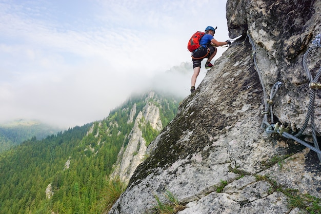 崖を登る男性登山家のローアングルショット