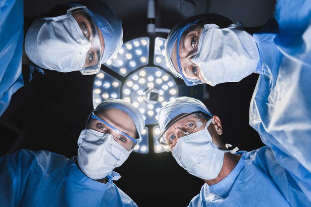 Low angle shot medical doctors performing surgery in operating\
room