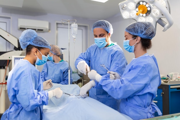 Low Angle Shot in the Operating Room Assistant Hands out Instruments to Surgeons During Operation Surgeons Perform Operation Professional Medical Doctors Performing Surgery