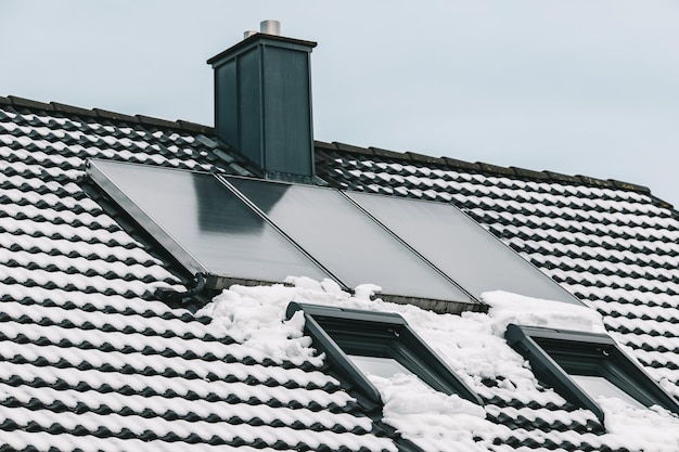 Low angle shot of a roof with skylight covered din the snow under a cloudy sky at daytime