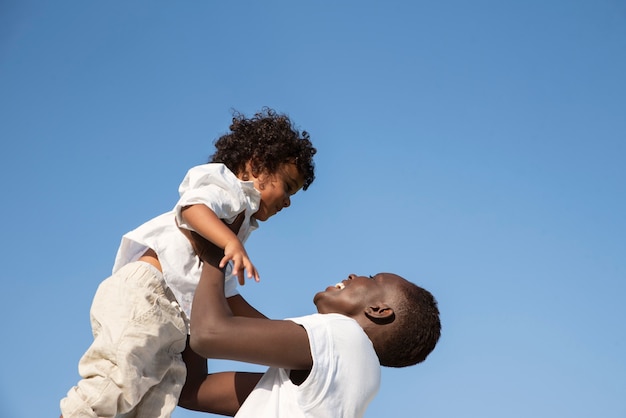 Photo low angle smiley mother holding kid