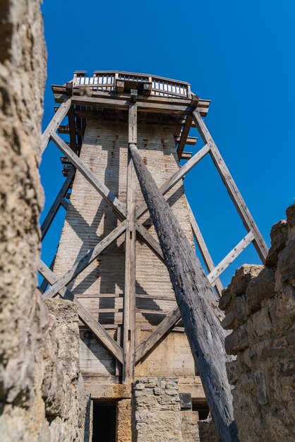 Low angle view of abandoned building against clear blue sky