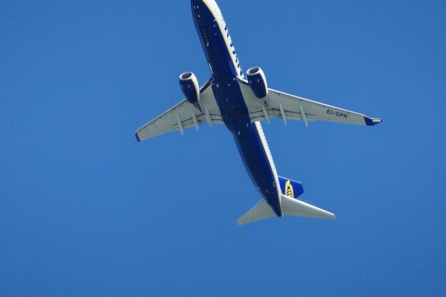 Low angle view of airplane against clear blue sky