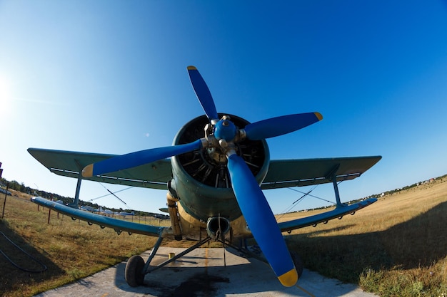 Photo low angle view of airplane on field against clear blue sky
