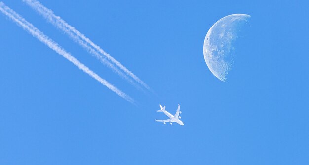 Low angle view of airplane flying against blue sky