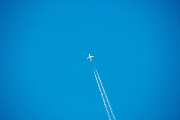 Low angle view of airplane flying against blue sky