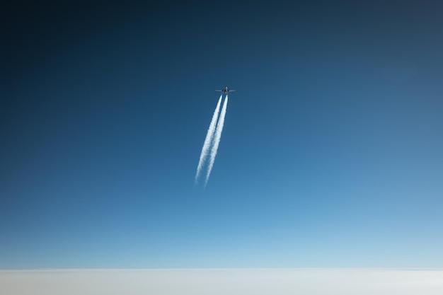 晴れた青い空を背景に飛行する飛行機の低角度の景色