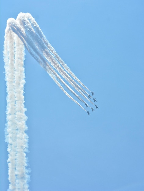 Низкий угол обзора самолета, летящего на фоне ясного голубого неба
