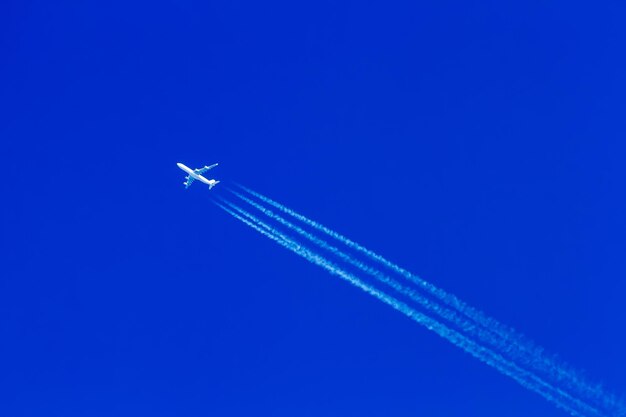 Photo low angle view of airplane flying against clear blue sky