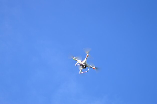 Low angle view of airplane flying against clear blue sky