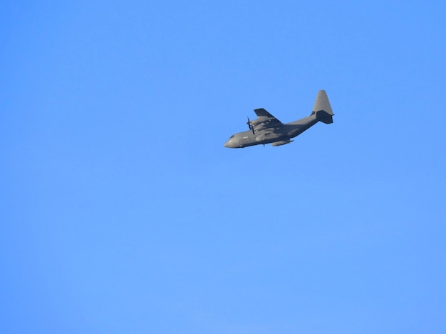 Low angle view of airplane flying against clear blue sky