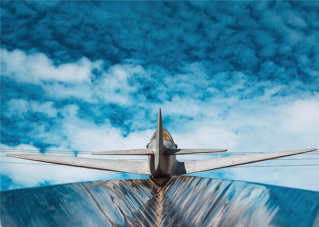 Low angle view of airplane flying against cloudy sky