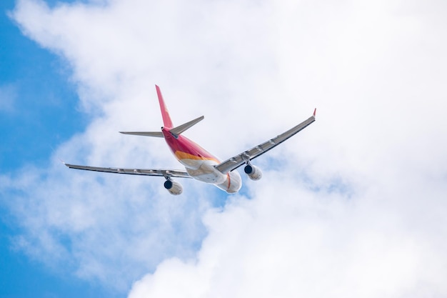 雲の空に照らして飛行している飛行機の低角度の景色