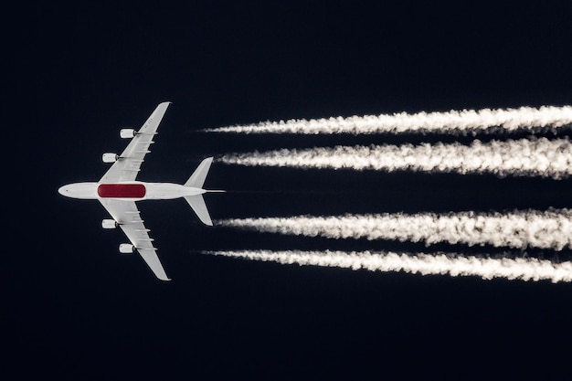 Foto vista a basso angolo di un aereo che vola contro il cielo notturno