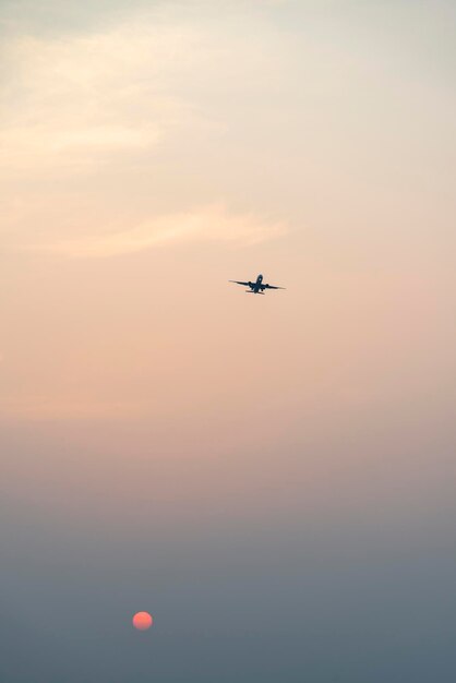 Foto vista a basso angolo di un aereo che vola nel cielo durante il tramonto