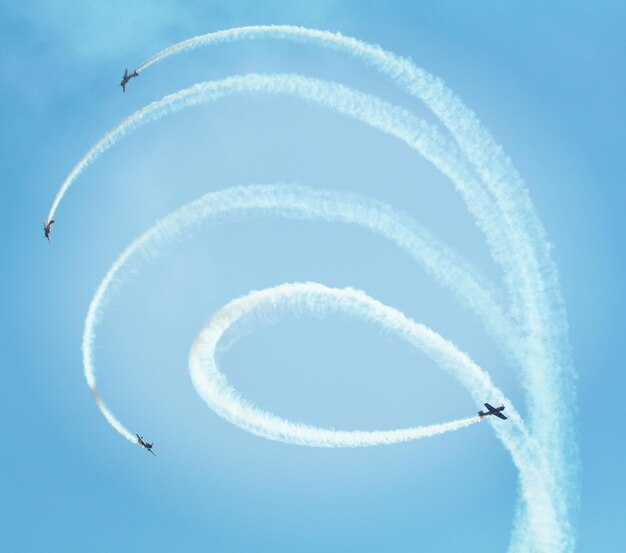 Photo low angle view of airplanes flying against blue sky