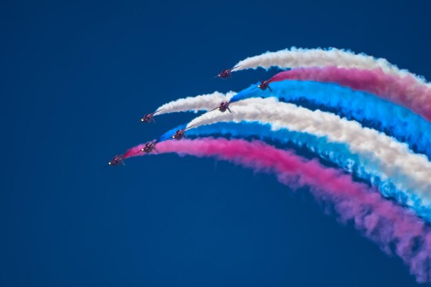 Photo low angle view of airshow against blue sky