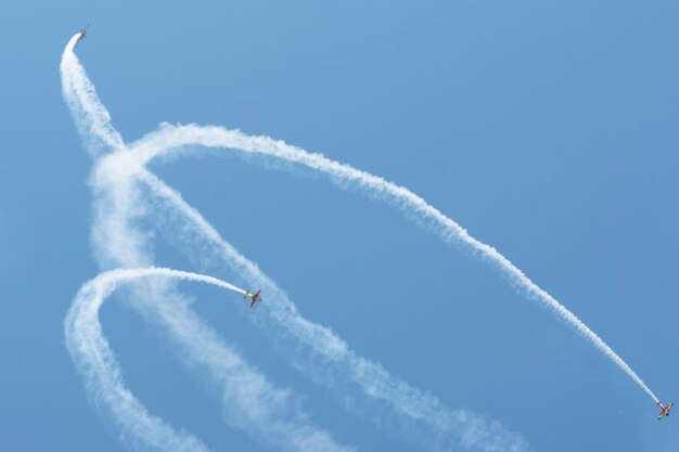 Photo low angle view of airshow against blue sky